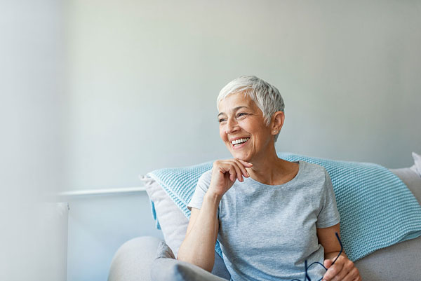 older woman sitting on the couch smiling