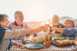 four friends having dinner next to a beach