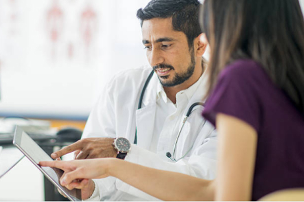 doctor speaks to a patient about dental treatment plan