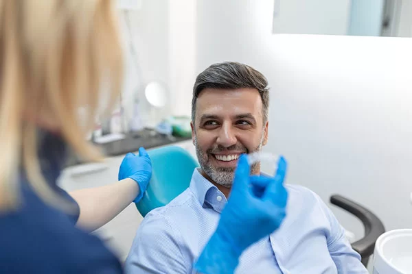 dentist showing patients his invisalign clear aligners