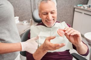 man holding a complete denture