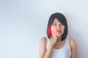 asian lady dealing with pain on her right cheek