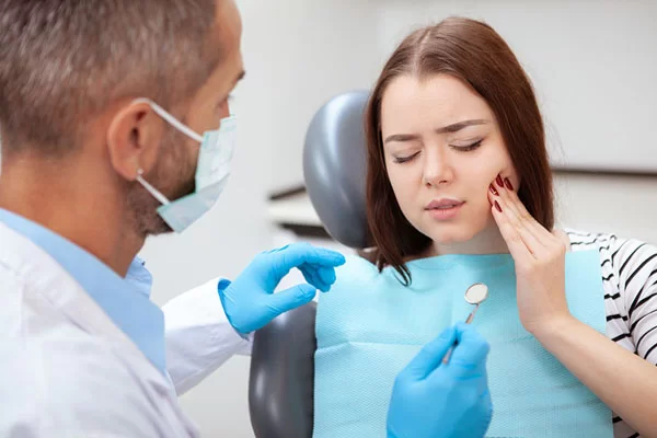 woman with jaw pain seeing a dentist