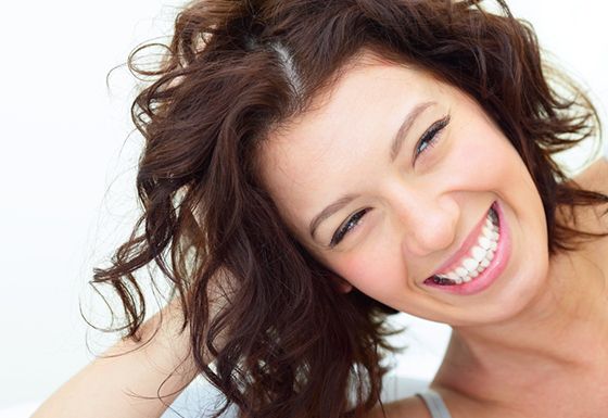 woman smiling after undergoing dental bonding treatment